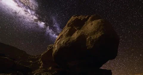 Starry night sky above rugged rock formations in a remote area Ilustração Stock