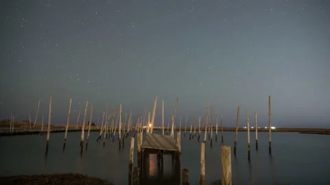 Starry night sky and clouds pass over an old pier in New Jersey Vidéo 194401491