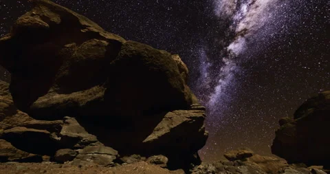 Starry night sky over large rock formations in remote desert location 库存影片 305439467
