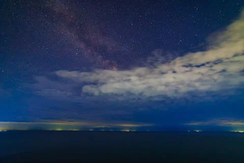 Starry night sky over large mountain lake at night Фото