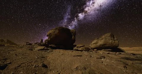 Starry night sky over rocky terrain in a remote desert location Ilustração Stock