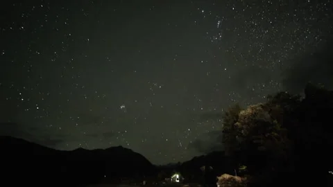 Starry night sky tilting down revealing mountain landscape Vídeos de archivo 334988393