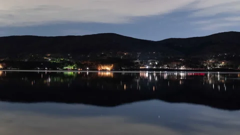 Starry Sky and Traffic Reflected in a Lake at Night (Time Lapse/Zoom In) Stock Footage 147962432
