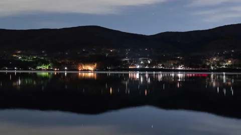 Starry Sky and Traffic Reflected in a Lake at Night (Time Lapse, Panning) Stockbeeldmateriaal 147973536