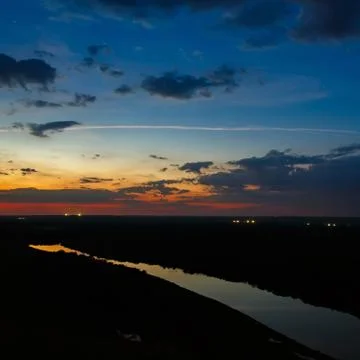 Starry sky with clouds over the river after sunset. Stock Photos