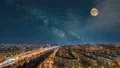 The starry sky with a moon above the beautiful city. time lapse 4k or 4k+ Resolution