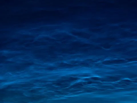 Starry sky with noctilucent clouds at summer solstice night. Fantastic clouds Stock Photos