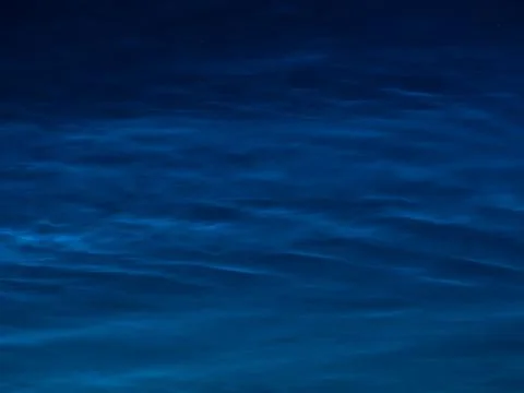 Starry sky with noctilucent clouds at summer solstice night. Fantastic clouds Stock Photos