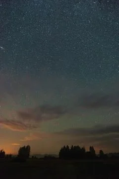 Starry sky over the forest over the fields and forests summer night and far f Stock Photos