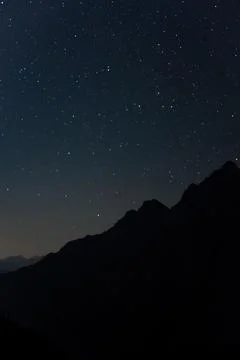 A starry sky over the mountain range in silhouette, night photography. Stock Photos