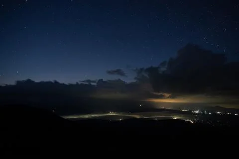 Starry sky with rain clouds and fog in a mountain village 库存照片