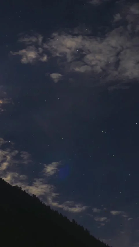 Stars and clouds moving across sky against a silhoutted mountain Stock Footage 342572684