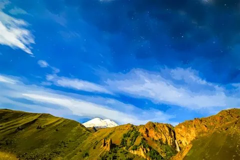 Stars and clouds over Mount Elbrus. Watercolor illustration. Night landscape. Ilustração Stock