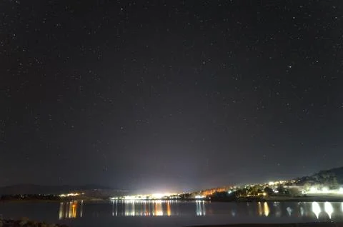 Stars arcing over a leafless tree on the shore of Lake Jindabyne Stock Photos