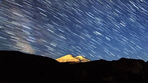 Stars draw lines and clouds over Mount Elbrus. Night landscape. Russia Stock Footage 84137793