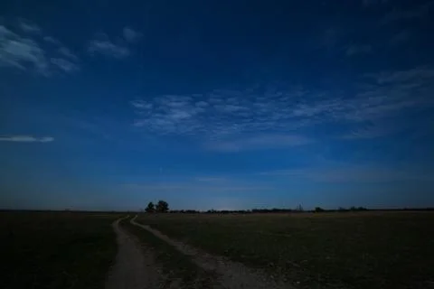 Stars in the night sky with clouds over the road. The landscape is photogra.. Stock Photos