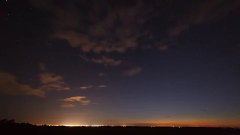 The stars in the night sky move around the polar star in the background  city. Stock Footage 77585368
