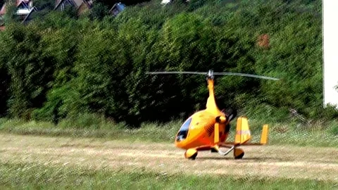 Start and take-off of an ultralight helicopter from the meadow airport Stock Footage 240416962
