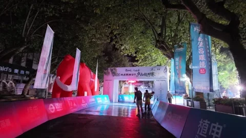 Start Area with Red Inflatable Mascot and Runners at Night, Lushan Stock Footage 346701532