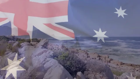On start Australian flag rippling over rocky headland, revealing coastline, Stock Footage 334768511