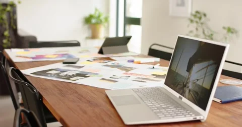 On start camera is shifting focus from laptop keys to notes, plant near window Stock Footage 335808732