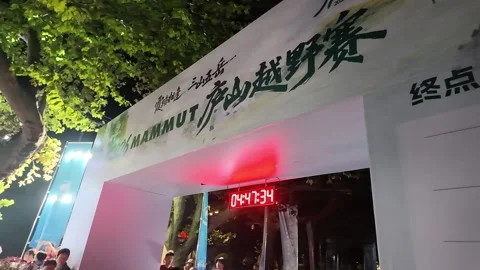 Start Finish Arch with Red Clock 04 47 and Crowd Behind Tape, Lushan Stock Footage 346701953
