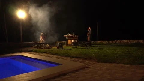 Start a fire with friends at a grill chatting and having drinks in a country hou 스톡 동영상 199594618