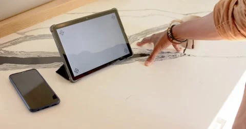At start, hand is sliding inward and is tracing marble pattern beside tablet to Stock Footage 342492963