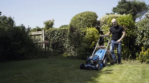 Start Lawn Mower and begin to cut grass moving left out of shot Stock Footage 111398394
