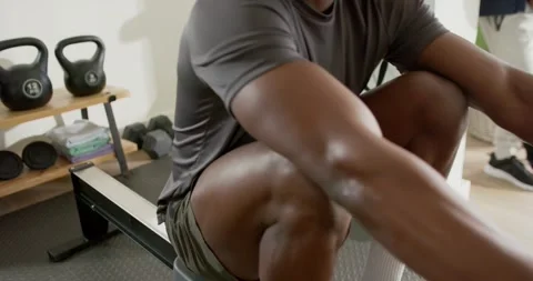 At start, man is bending knees and sliding seat for recovery on rowing machine Stock Footage 340611678