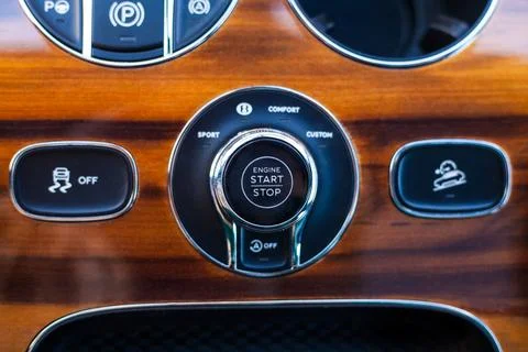 Start stop button on wooden panel of modern luxury car with suspension cont.. Stock Photos