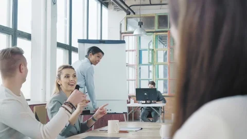 Start up team holds a meet up at a large table. Mixed-race woman manager holds a Stock Footage 108210887