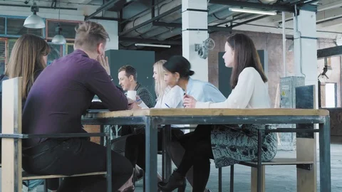 Start up team holds a meeting at a large table. Mixed-race woman manger gets up Stock Footage 108210618