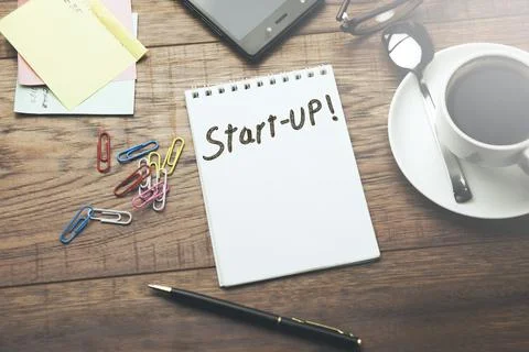 Start-up word on notebook on working table Stock Photos