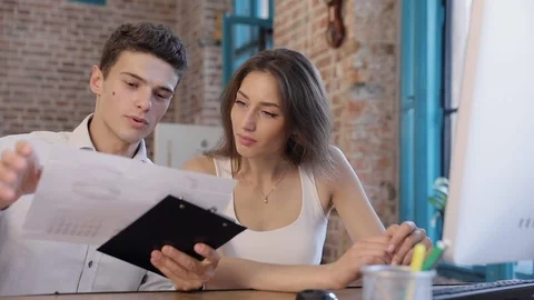 Start up of Young Creative Team. Couple Sitting at the Table in the Office Stock Footage 93484181