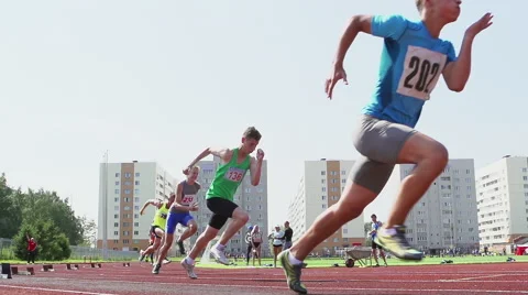 A start of young runners on a stadium - slow motion, feet level Stock Footage
