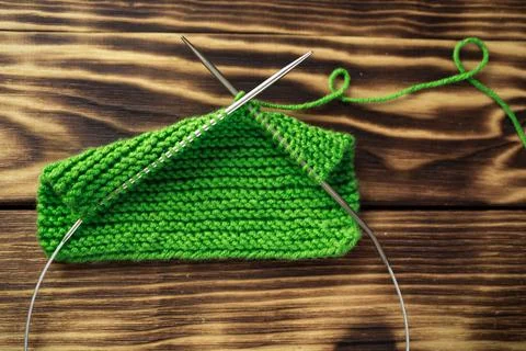Started knitting on knitting needles, with yarn on a rustic wooden table, with Stock Photos