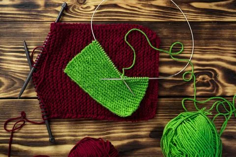 Started knitting on knitting needles, with yarn on a rustic wooden table, with Stock Photos