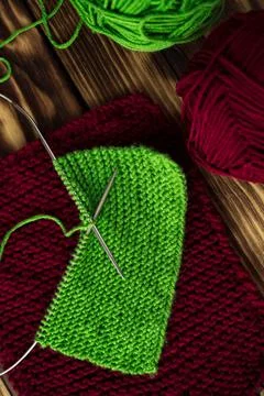 Started knitting on knitting needles, with yarn on a rustic wooden table, with Stock-Fotos