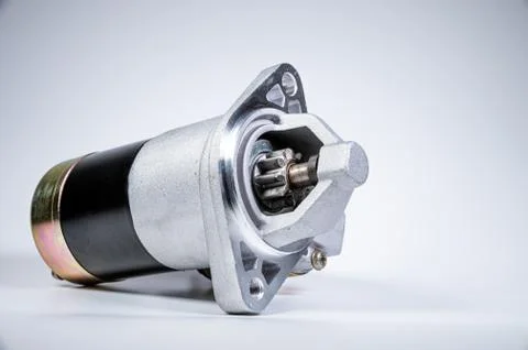 Starter of an internal combustion engine New Spare part for car on a gray Illustrazione stock