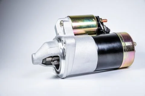Starter of an internal combustion engine New Spare part for car on a gray Fotos de archivo