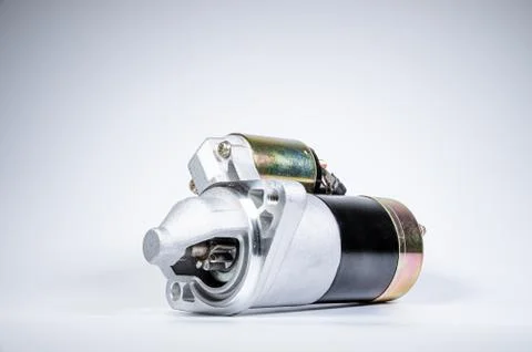 Starter of an internal combustion engine New Spare part for car on a gray Fotos de archivo