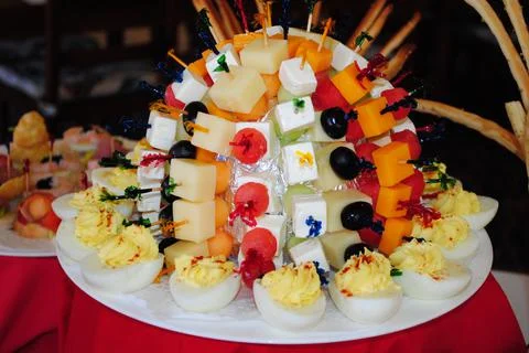 Starters of cheese cubes and deviled eggs in a white platter 스톡 사진