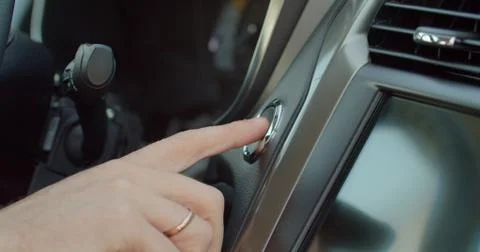 Starting car engine. Track in to the button. Finger press the button to start Stock Photos