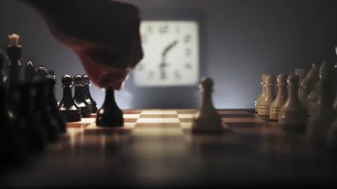 Starting chess game in real time in dark environment with clock in background Stock Footage 312825388