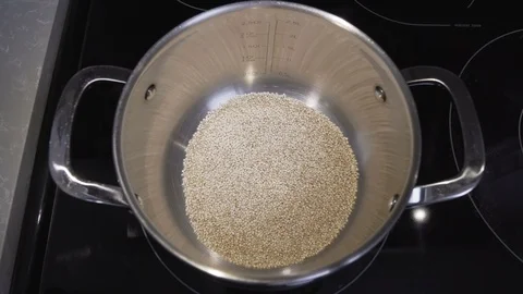 Starting the Cooking Process for Quinoa Stock Footage 106328788