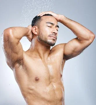 Starting the day on a clean note. Studio shot of a handsome young man taking a Stock Photos