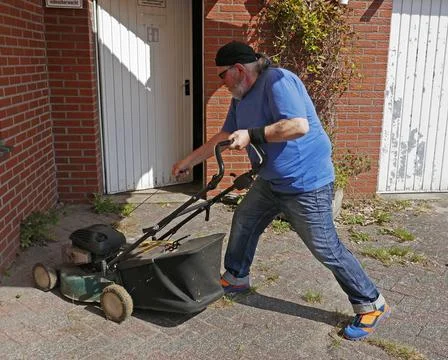 Starting a gas lawnmower with a cord Stock Photos