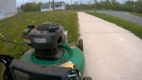 Starting lawn mower 4k side view in neighbourhood 動画素材 109132911