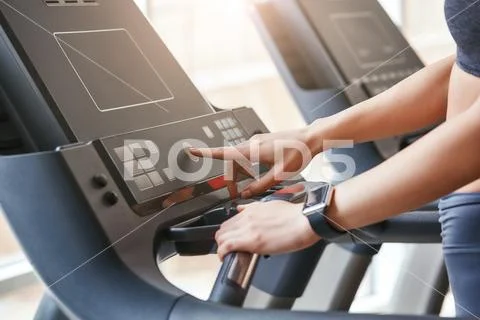 Starting to run. Close up photo of woman in sportswear pushing a start button on Stock Photos